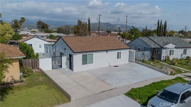 single story home with a residential view, roof with shingles, stucco siding, driveway, and fence