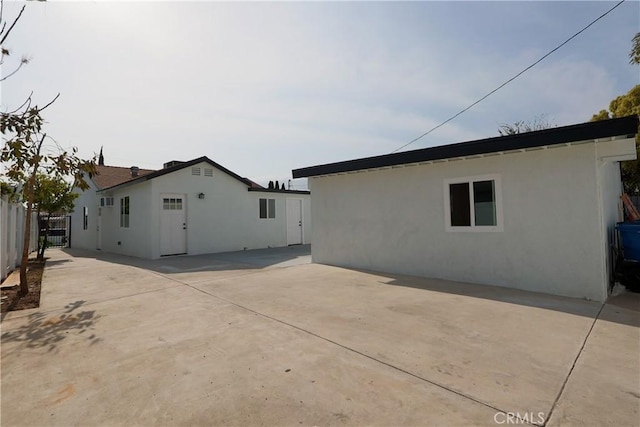 back of property with a patio, stucco siding, and fence