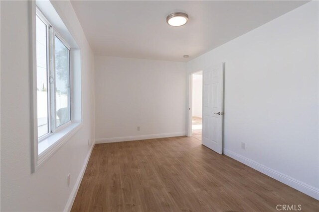 empty room with baseboards and wood finished floors