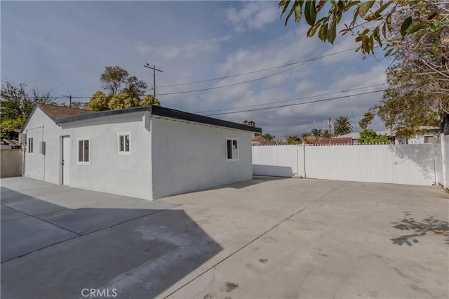 exterior space featuring a patio area, stucco siding, and fence
