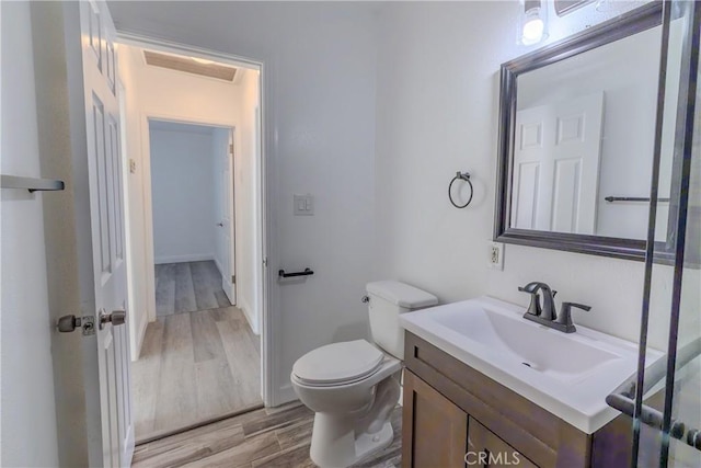 bathroom featuring visible vents, toilet, vanity, and wood finished floors