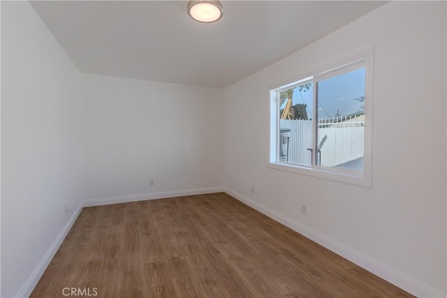 empty room with wood finished floors and baseboards