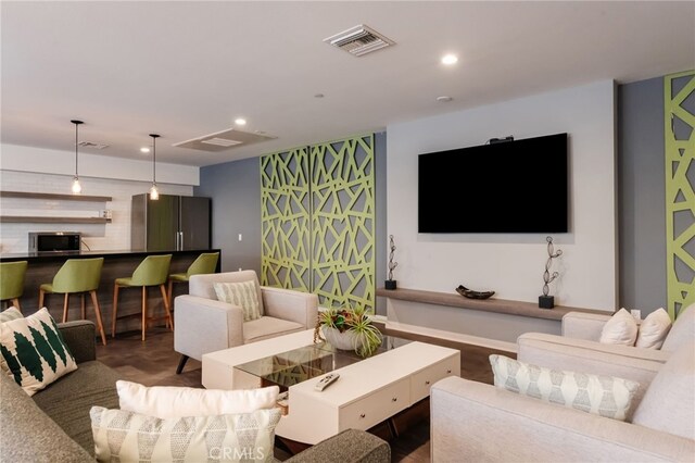 living room featuring recessed lighting and visible vents