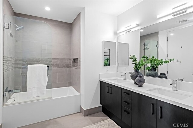 full bath with double vanity, a sink, tub / shower combination, and tile patterned floors