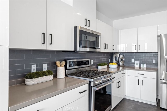 kitchen with white cabinets, stainless steel appliances, light countertops, and tasteful backsplash