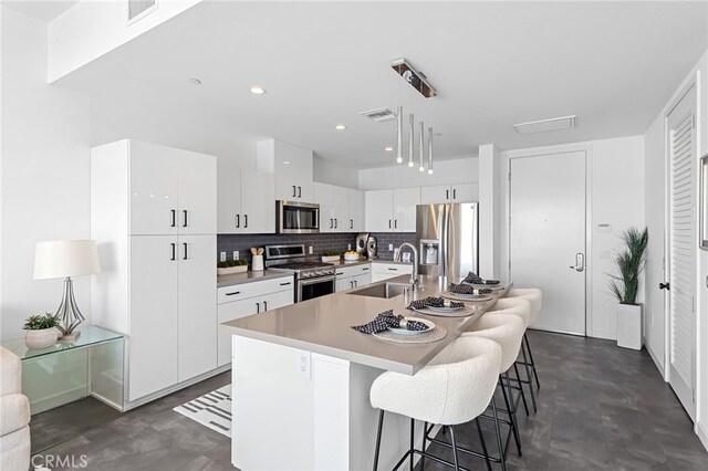 kitchen featuring a sink, appliances with stainless steel finishes, finished concrete flooring, and visible vents