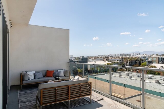 balcony with an outdoor living space and a city view