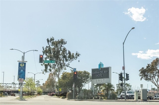 view of street with traffic lights, traffic signs, curbs, and street lighting