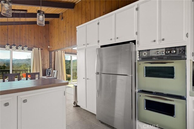 27994 W Shore Rd, Lake Arrowhead, CA 92352 - kitchen featuring freestanding refrigerator, multiple ovens, plenty of natural light, wooden walls, and white cabinetry