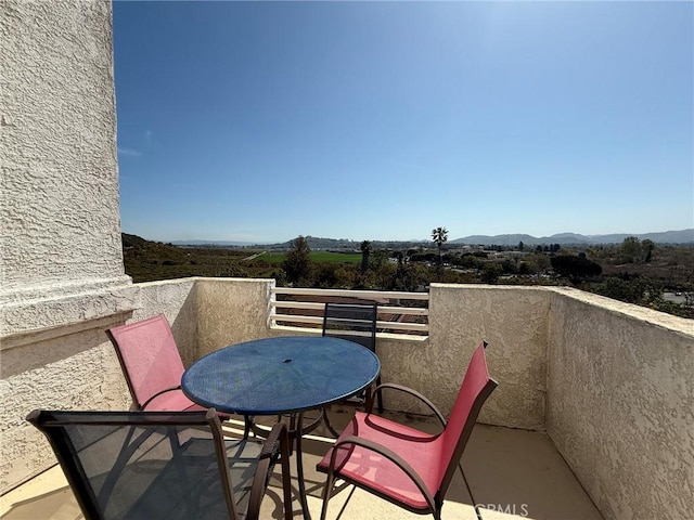 balcony featuring outdoor dining area and a mountain view