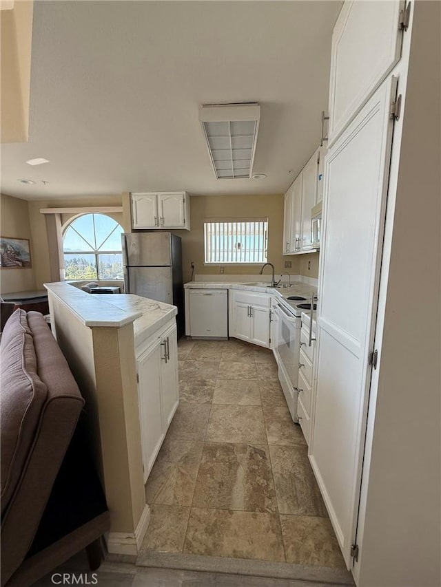 kitchen featuring white cabinets, plenty of natural light, and stainless steel appliances