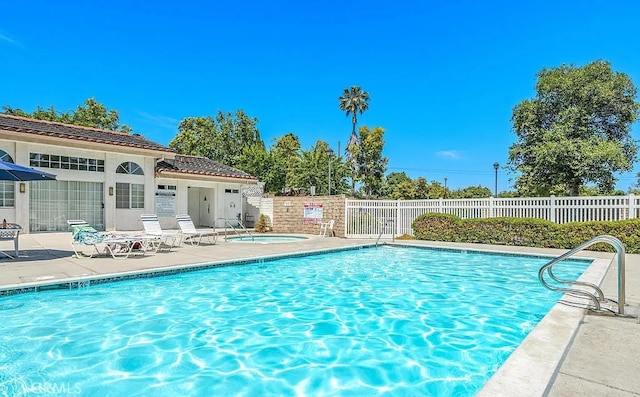 pool featuring fence and a patio area