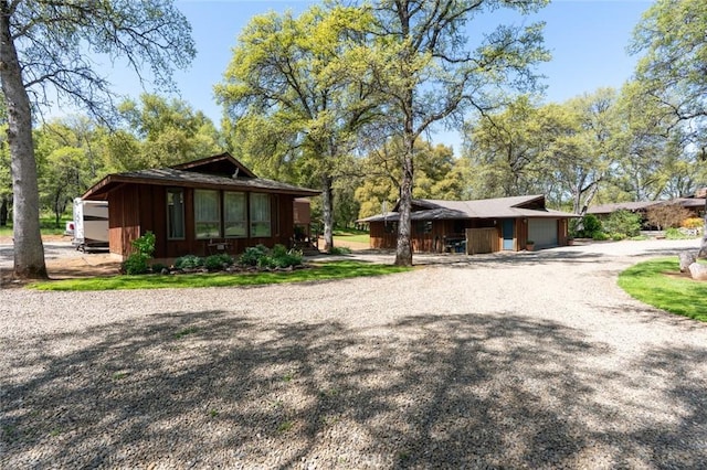 exterior space with an attached garage and gravel driveway