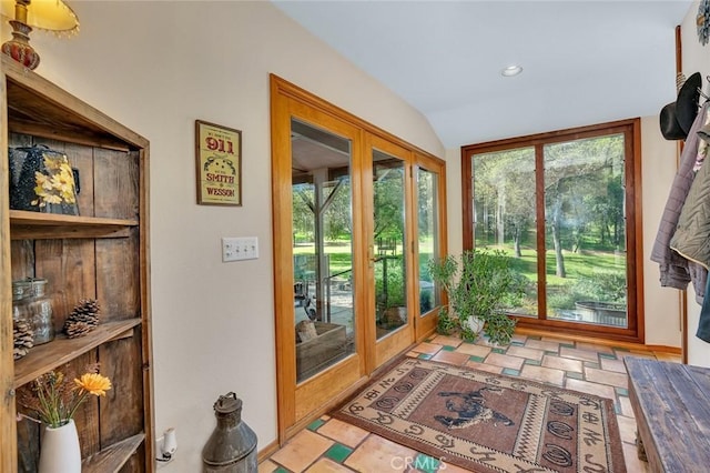 doorway to outside featuring recessed lighting, a wealth of natural light, stone finish flooring, and lofted ceiling