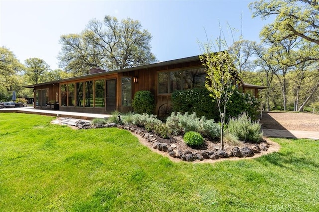 back of property featuring a chimney and a yard