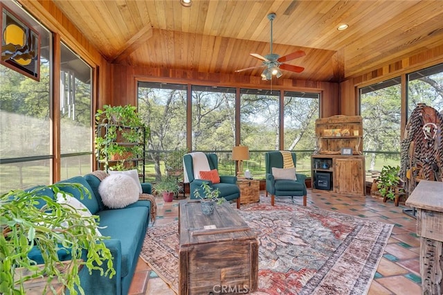 sunroom / solarium featuring a ceiling fan, an outdoor living space with a fireplace, and a wealth of natural light