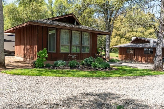 view of side of property with gravel driveway
