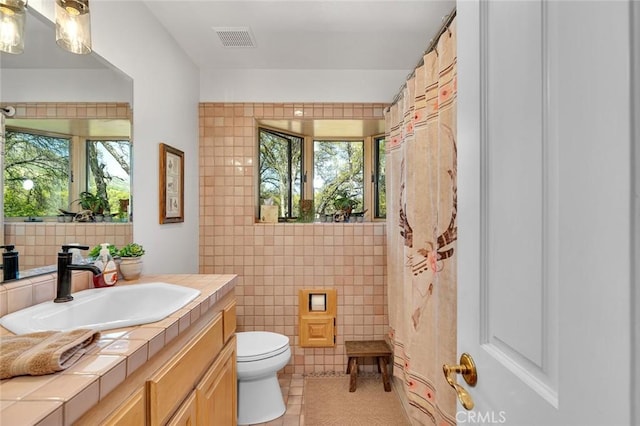bathroom featuring tile walls, a wealth of natural light, tile patterned floors, and visible vents