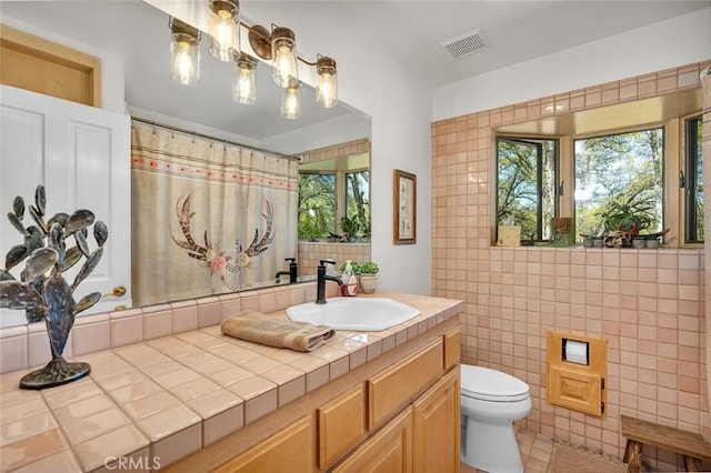 full bathroom featuring visible vents, tile walls, vanity, toilet, and a shower with shower curtain
