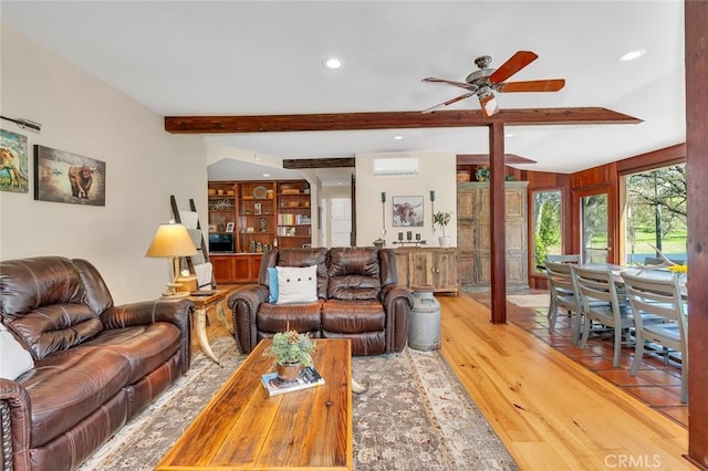 living area with beam ceiling, ceiling fan, light wood-type flooring, recessed lighting, and a wall unit AC