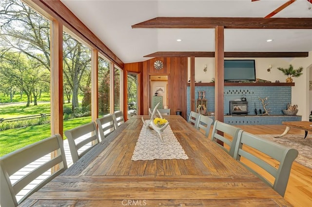 sunroom with wooden walls and vaulted ceiling with beams