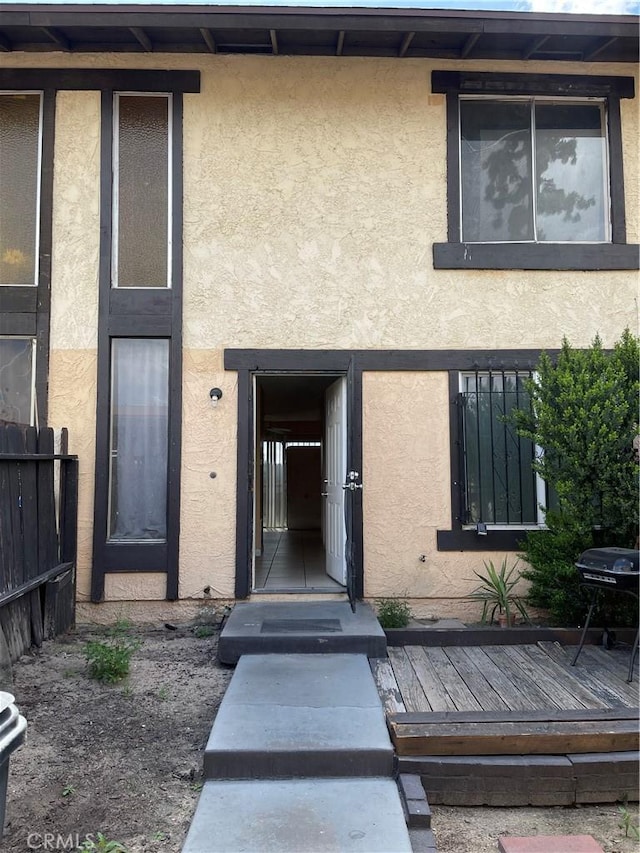 26873 Mossway St, Highland, CA 92346 - doorway to property featuring stucco siding and fence