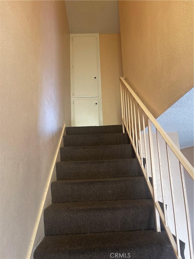 26873 Mossway St, Highland, CA 92346 - stairway featuring a textured ceiling