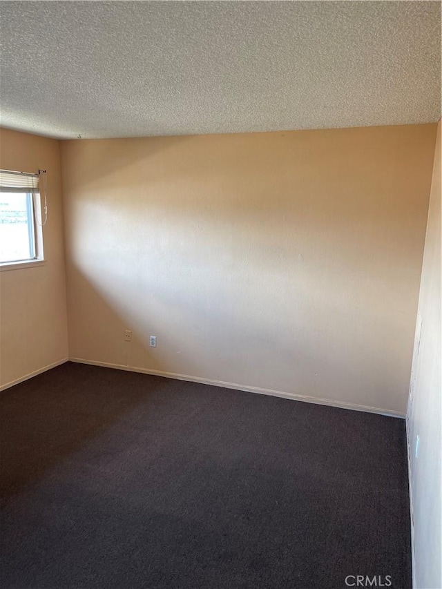 26873 Mossway St, Highland, CA 92346 - empty room featuring dark carpet, baseboards, and a textured ceiling