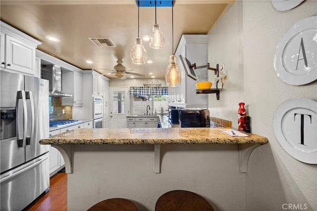 805 W Brentwood Ave, Orange, CA 92865 - kitchen featuring stainless steel appliances, wall chimney exhaust hood, decorative backsplash, a peninsula, and ceiling fan