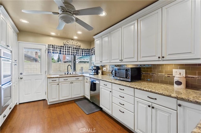 805 W Brentwood Ave, Orange, CA 92865 - kitchen featuring stainless steel appliances, white cabinetry, decorative backsplash, light wood-type flooring, and recessed lighting
