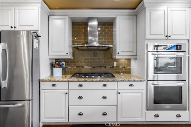 805 W Brentwood Ave, Orange, CA 92865 - kitchen with appliances with stainless steel finishes, wall chimney range hood, decorative backsplash, and white cabinets