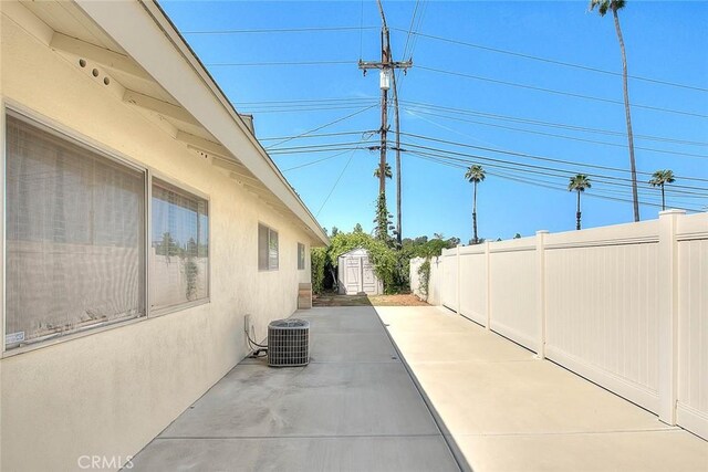 6087 Academy Ave, Riverside, CA 92506 - exterior space featuring stucco siding, a patio area, central AC, a fenced backyard, and an outbuilding