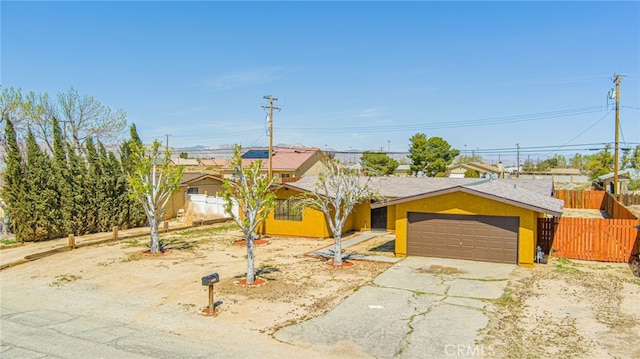 ranch-style home with an attached garage, fence, and driveway