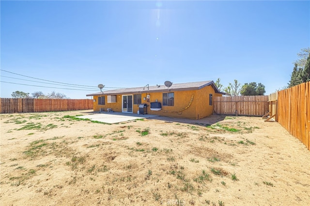 rear view of house with a patio area and a fenced backyard