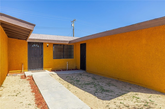 property entrance with stucco siding