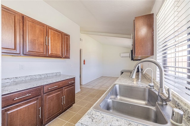 kitchen with light tile patterned floors, light countertops, a sink, and lofted ceiling