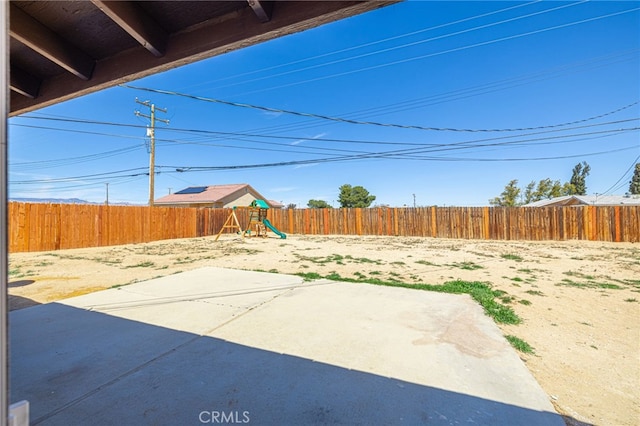 view of yard with a patio area, a fenced backyard, and a playground