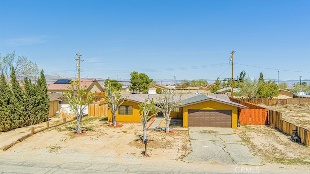 ranch-style home with a garage, driveway, and fence