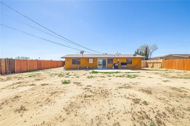 rear view of house featuring a fenced backyard and a patio area