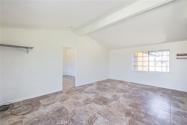 unfurnished room with vaulted ceiling with beams and stone finish flooring