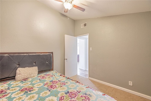 carpeted bedroom with baseboards, vaulted ceiling, a textured wall, visible vents, and ceiling fan