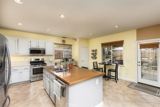 29567 Cool Meadow Dr, Menifee, CA 92584 - kitchen with appliances with stainless steel finishes, light tile patterned floors, white cabinets, recessed lighting, and a kitchen island with sink