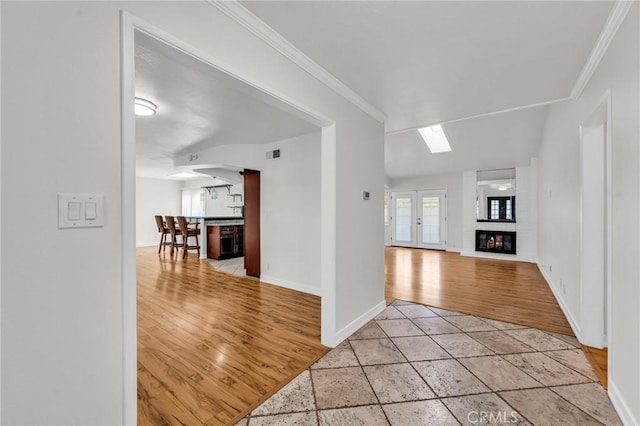 12195 Monte Vista Ave, Chino, CA 91710 - interior space featuring baseboards, crown molding, light wood-style floors, a skylight, and arched walkways