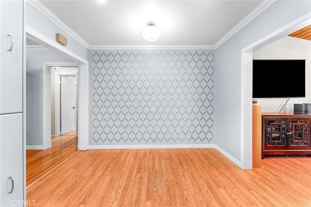 unfurnished room featuring crown molding, baseboards, and light wood-type flooring