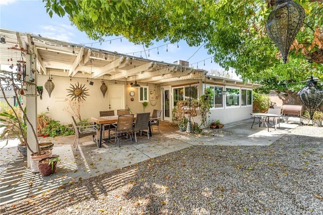 back of house with a patio, outdoor dining area, and stucco siding