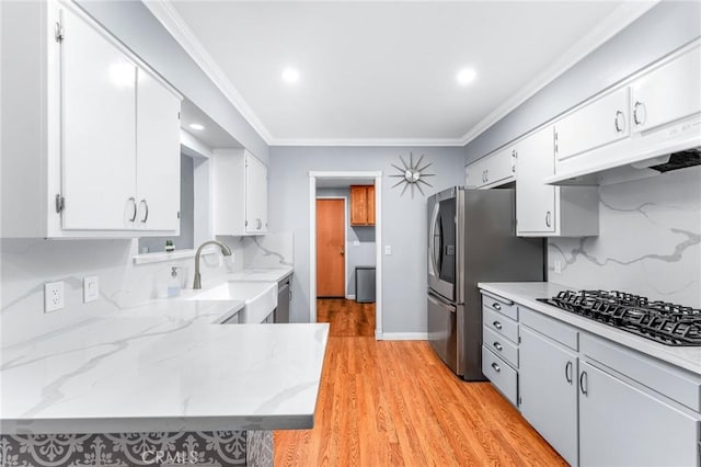 kitchen with black gas cooktop, white cabinetry, a sink, and decorative backsplash