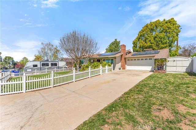 single story home with a fenced front yard, a garage, driveway, and solar panels