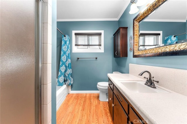 bathroom featuring baseboards, ornamental molding, toilet, vanity, and wood finished floors