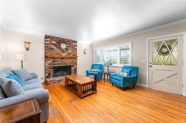 living area with a fireplace, light wood-style flooring, and crown molding