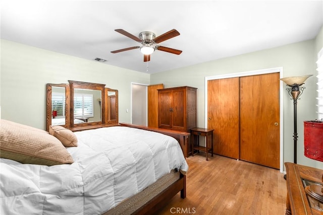 bedroom featuring a closet, light wood finished floors, a ceiling fan, and visible vents